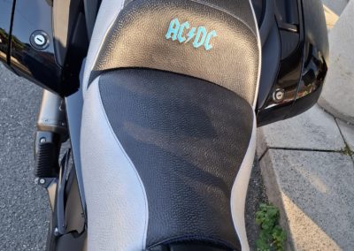 BMW K1300 : ajout de matelassage pour le confort du pilote, changement en selle bicolore et ajout de la broderie AC/DC dans les couleurs du logo de BMW